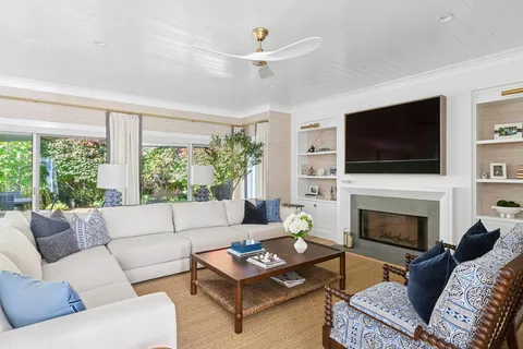 a living room with furniture a flat screen tv and a fireplace