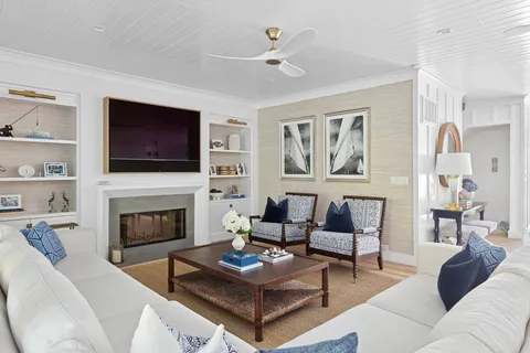a living room with furniture a fireplace and a flat screen tv