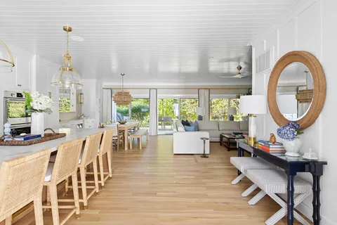 a living room with furniture a table and large windows