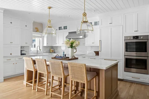 a kitchen with stainless steel appliances kitchen island granite countertop a table chairs and a refrigerator