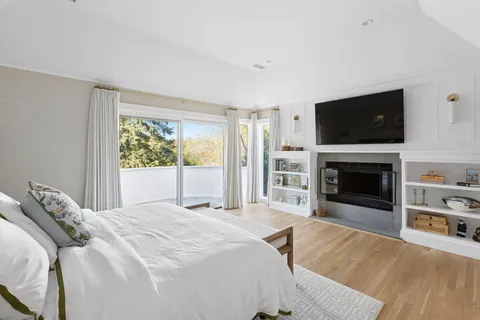 a spacious bedroom with a bed and a flat screen tv