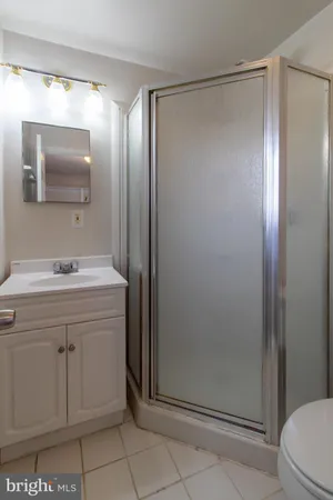 a bathroom with a shower sink and mirror