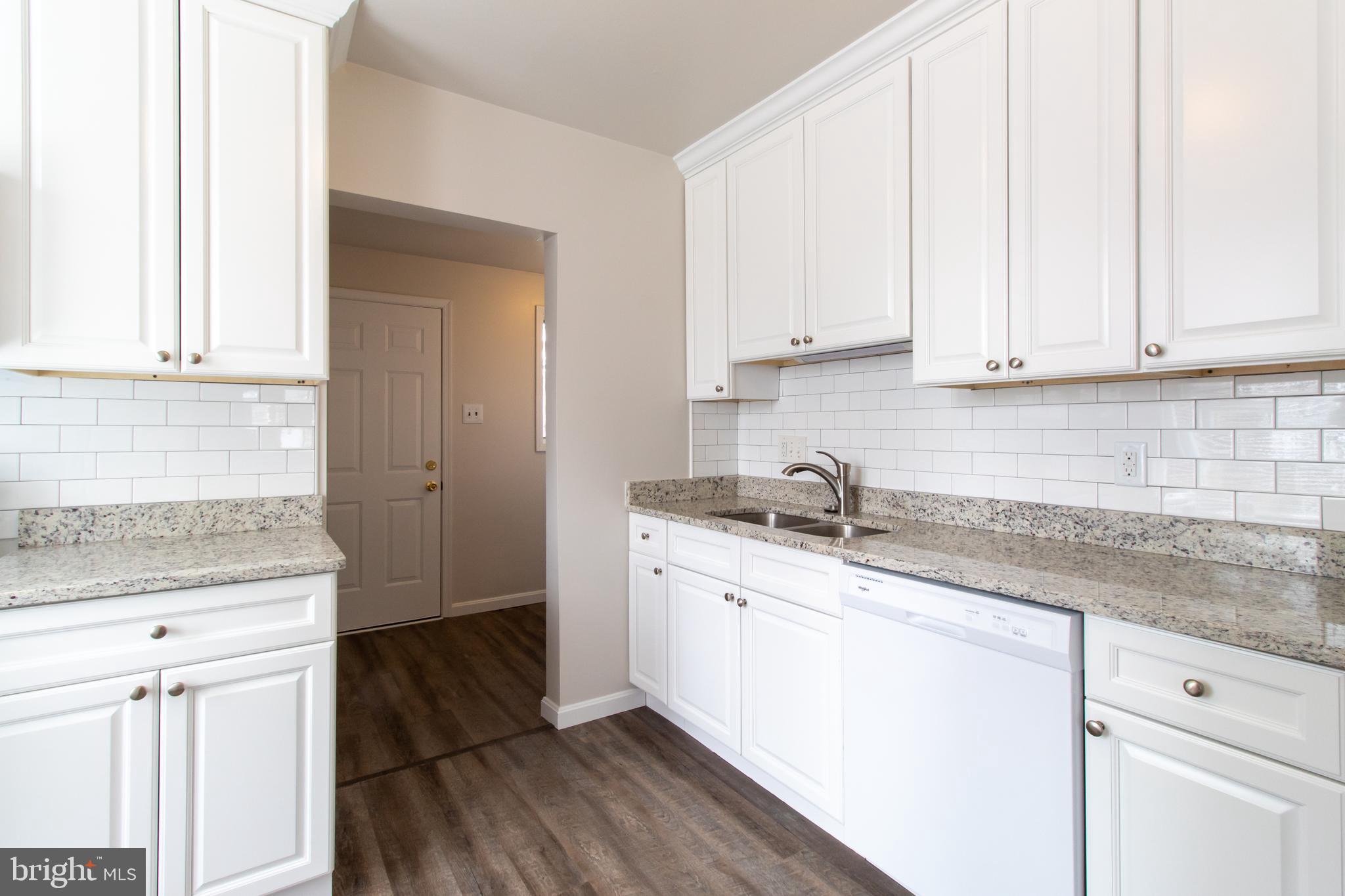 9440 Riggs Road Adelphi, MD 20783 - Photo 6 of 18 a kitchen with granite countertop white cabinets and white appliances