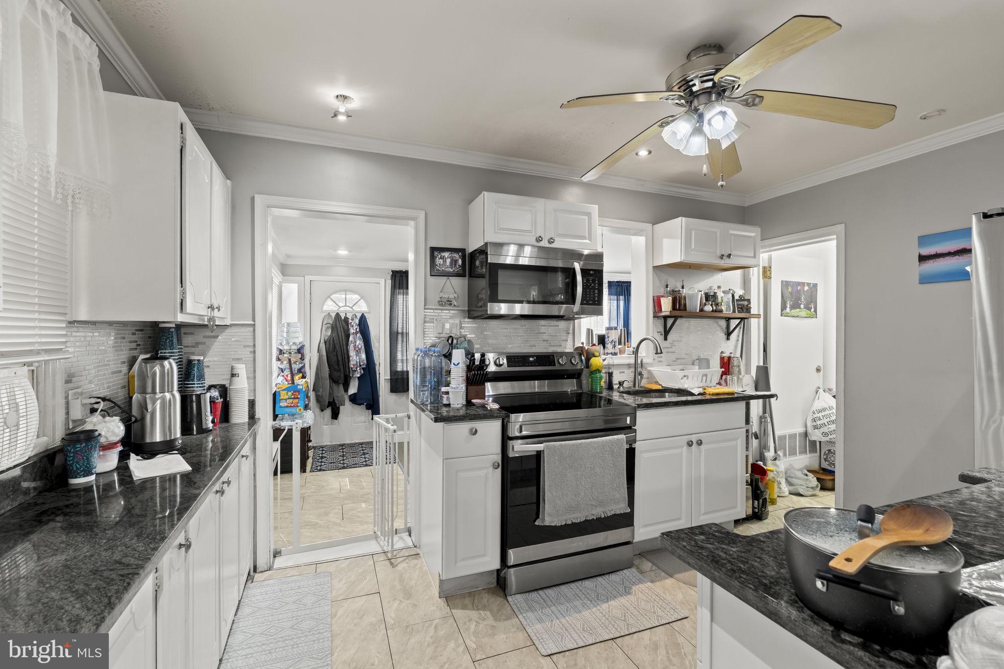 3105 Newportville Road Bristol, PA 19007 - Photo 5 of 30 a kitchen with stainless steel appliances kitchen island granite countertop a sink dishwasher stove and white cabinets