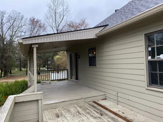 a view of a house with a large window and wooden fence
