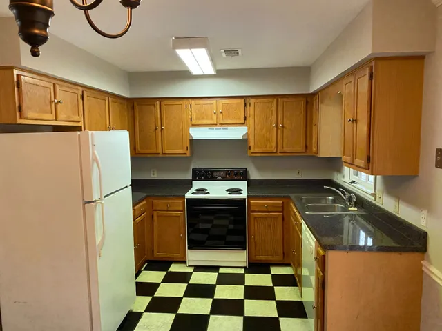 a kitchen with a stove a refrigerator and a sink