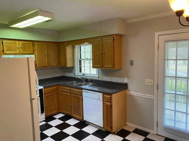 a kitchen with a sink a refrigerator and cabinets