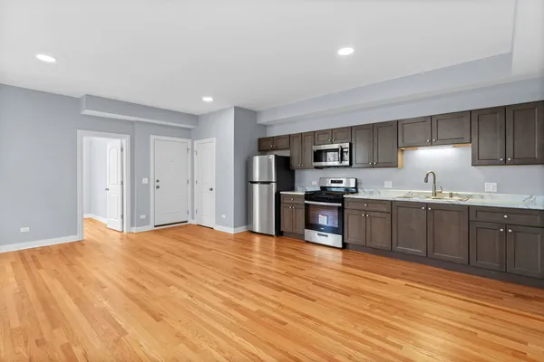a kitchen with granite countertop stainless steel appliances refrigerator sink and cabinets