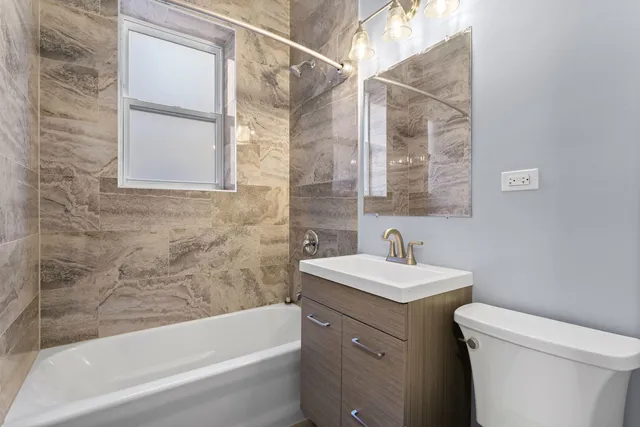 a bathroom with a sink toilet vanity and bathtub