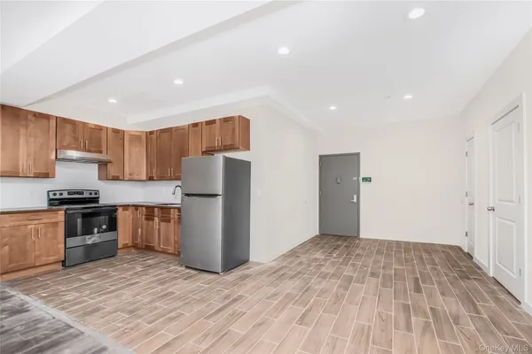 a kitchen with granite countertop a refrigerator and a stove top oven