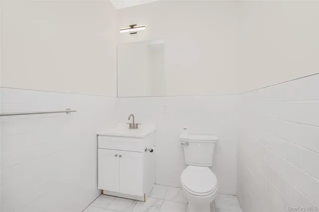 a bathroom with a toilet a sink and mirror