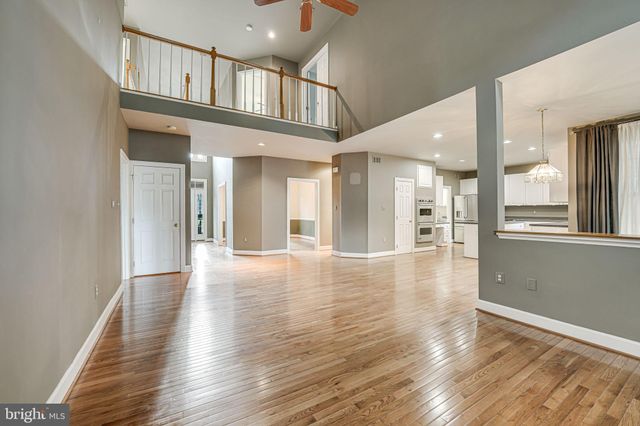 a large kitchen with stainless steel appliances kitchen island a large counter top and wooden floors