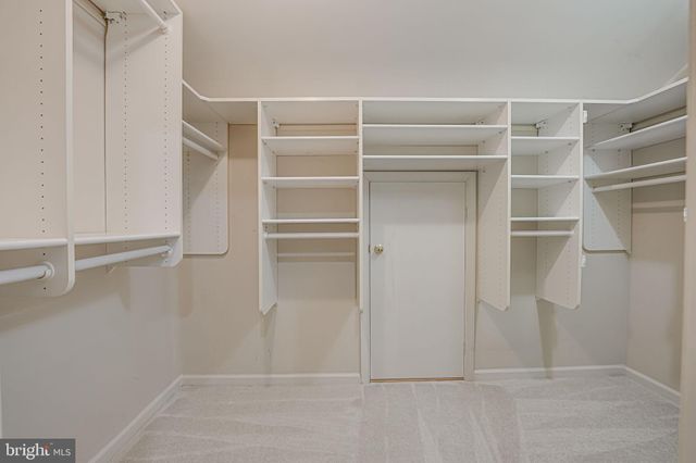 a view of an empty room and chandelier fan