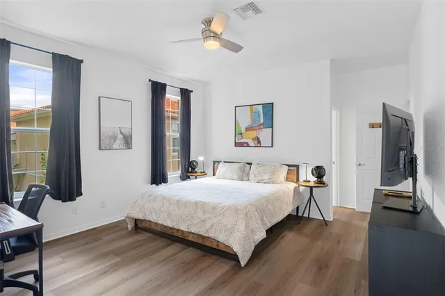 a bedroom with a bed wooden floor and a window