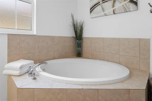 a bathroom with a white tub and a window
