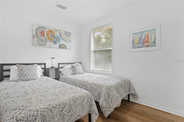a bedroom with two beds and a painting on the wall