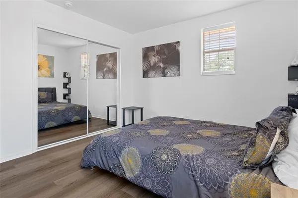 a bedroom with a bed a mirror and lamp