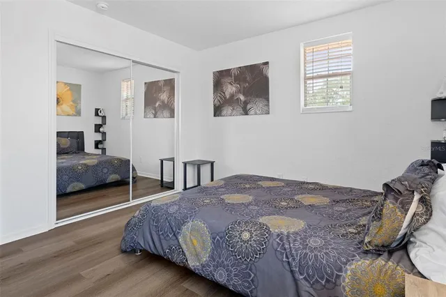 a bedroom with a bed a mirror and lamp