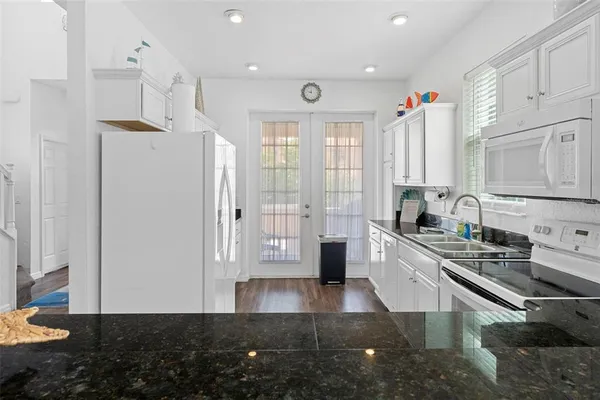 a kitchen with stainless steel appliances granite countertop a sink stove and refrigerator
