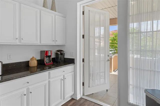 a kitchen with stainless steel appliances granite countertop white cabinets and a window