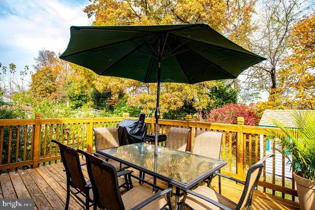 a view of deck with table and chairs under an umbrella with wooden floor