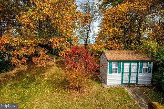 a front view of a house with garden and trees