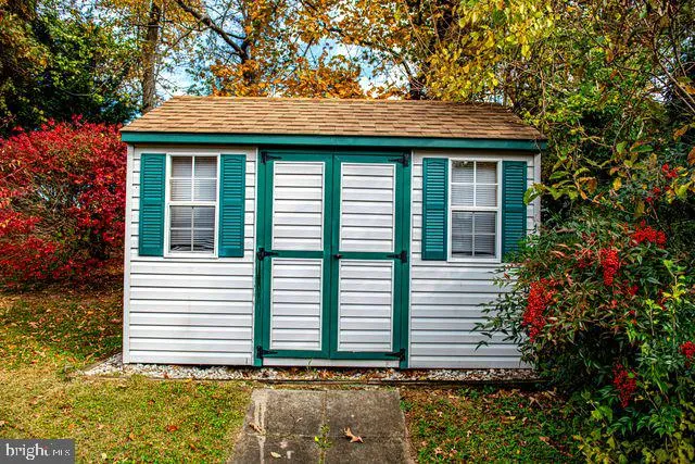 a front view of a house with a garden and trees