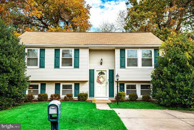 a view of house with yard and car parked