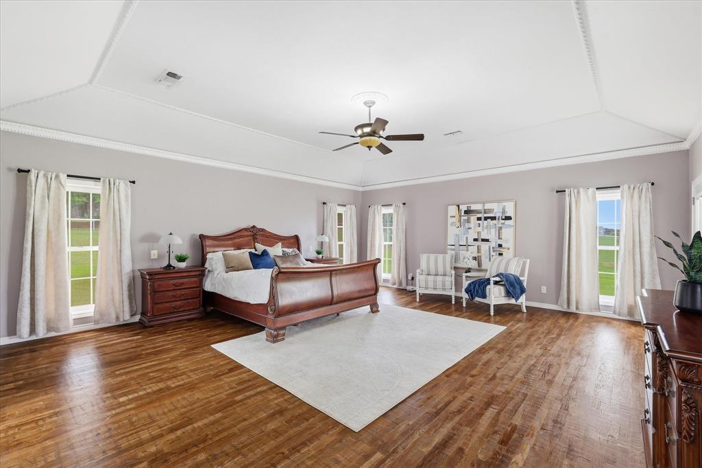 6955 Hawk Road Flower Mound, TX 75022 - Photo 21 of 40 Spacious room featuring wood-finish flooring, multiple windows, a tray ceiling with crown molding, and a ceiling fan