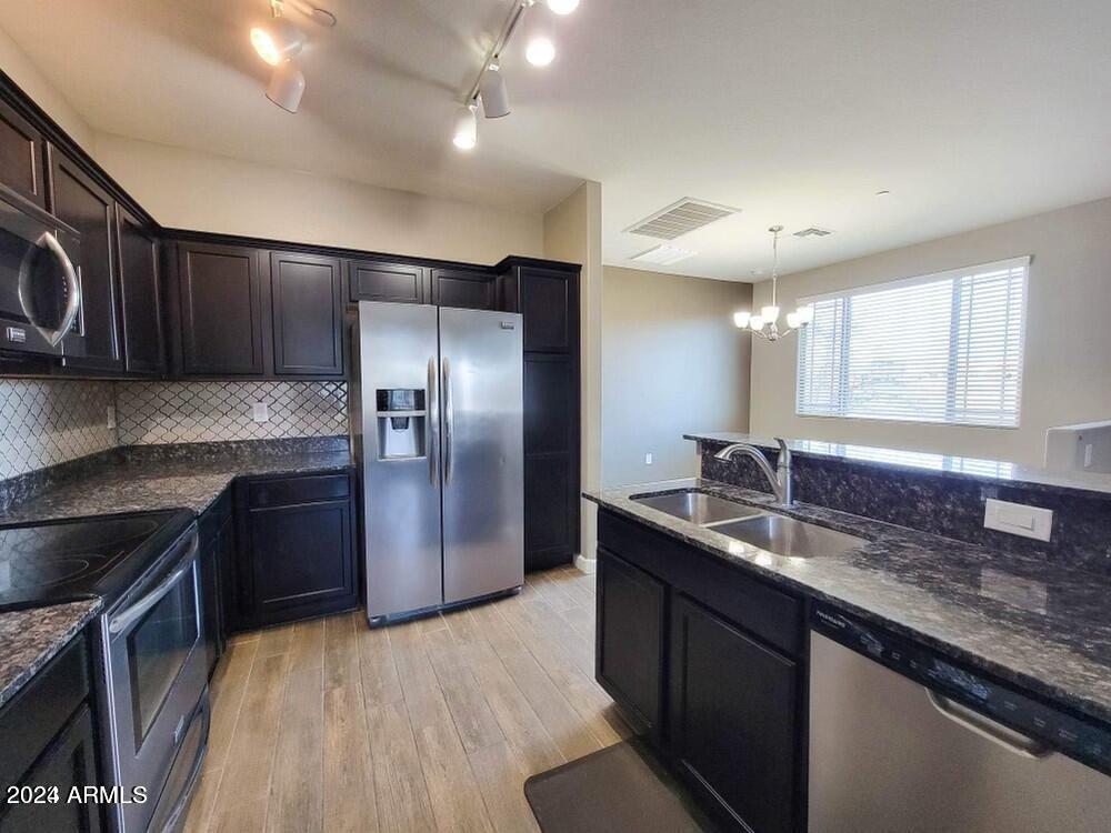 2150 West Alameda Road, Unit 1169 Phoenix, AZ 85085 - Photo 22 of 26 a kitchen with stainless steel appliances granite countertop a sink stove and refrigerator