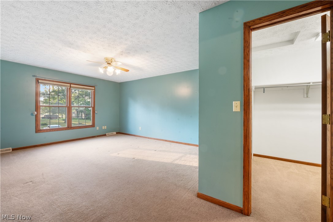 1239 Congress Lake Road Mogadore, OH 44260 - Photo 16 of 35 Unfurnished bedroom with a closet, a textured ceiling, ceiling fan, and light colored carpet