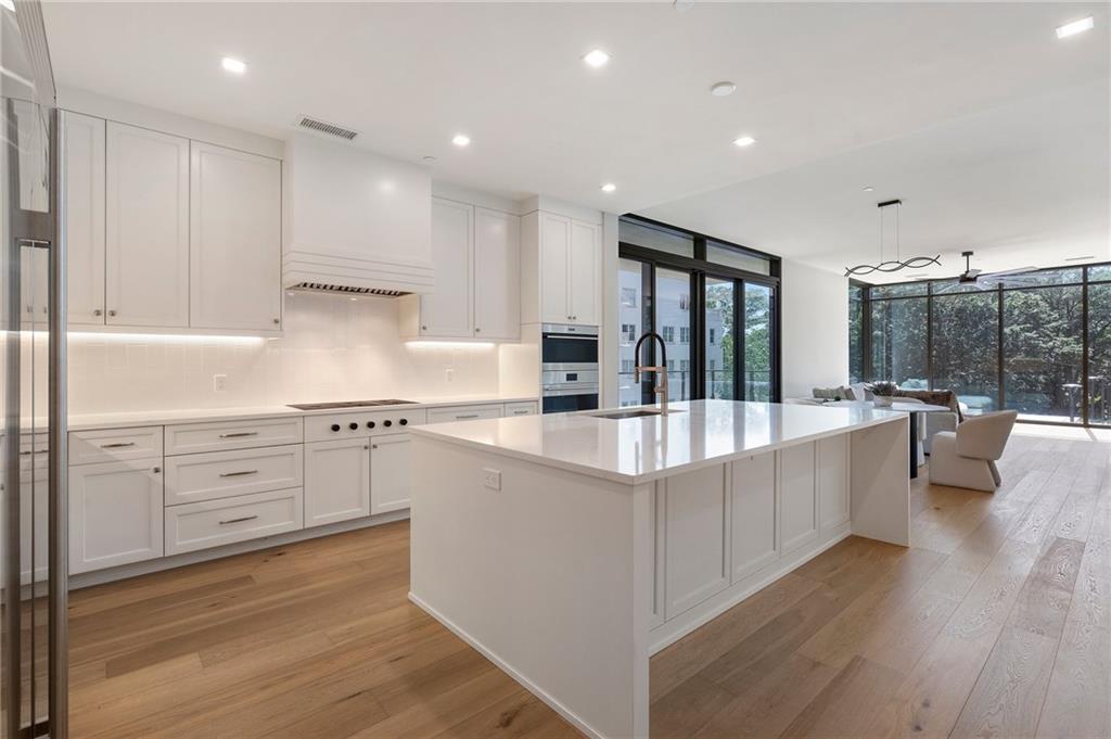 2520 Peachtree Road Northwest, Unit 403 Atlanta, GA 30305 - Photo 3 of 52 a large kitchen with kitchen island a large window a sink and stainless steel appliances