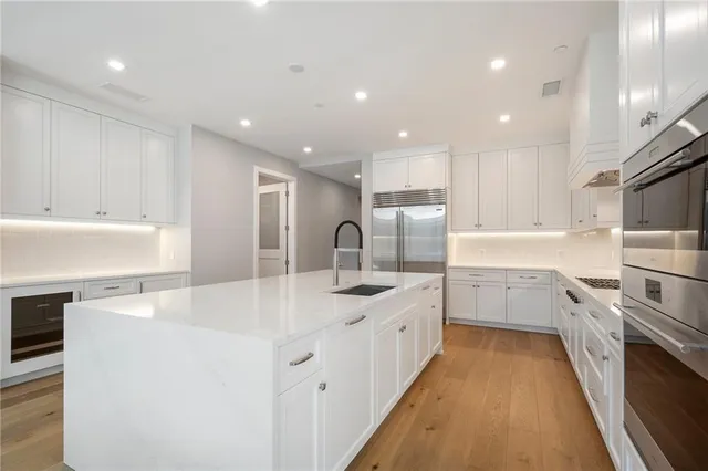 a kitchen with white cabinets appliances and sink