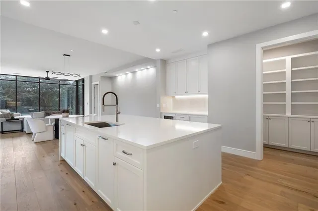 a large white kitchen with a sink and dish washer