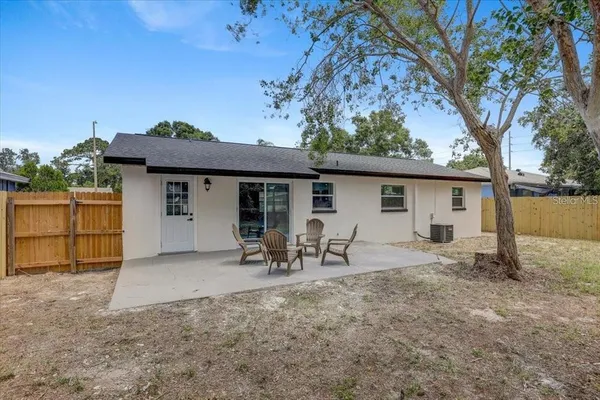 a view of a house with backyard and a tree