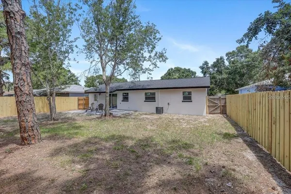 a view of a house with a yard and large tree