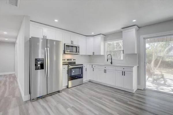 a kitchen with stainless steel appliances a refrigerator sink and microwave