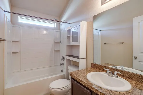 a bathroom with a granite countertop sink toilet and shower