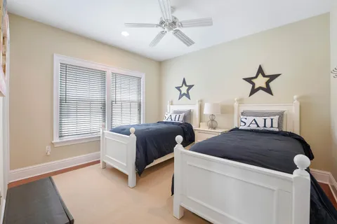 a spacious bedroom with two beds and chandelier