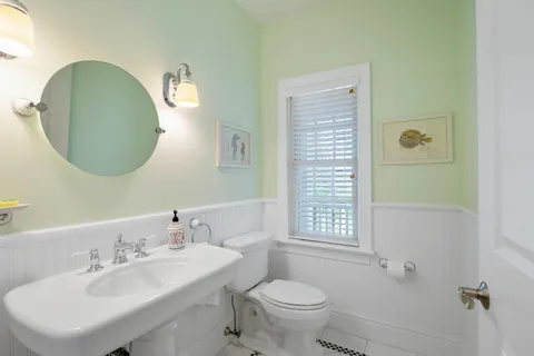 a bathroom with a sink toilet and a mirror