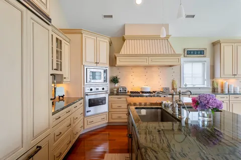 a kitchen with stainless steel appliances granite countertop a stove a sink and a refrigerator