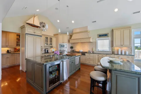a kitchen with kitchen island granite countertop a sink cabinets and wooden floor