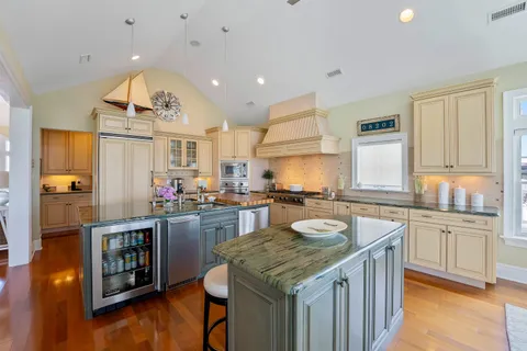 a kitchen with kitchen island granite countertop a sink stove and cabinets