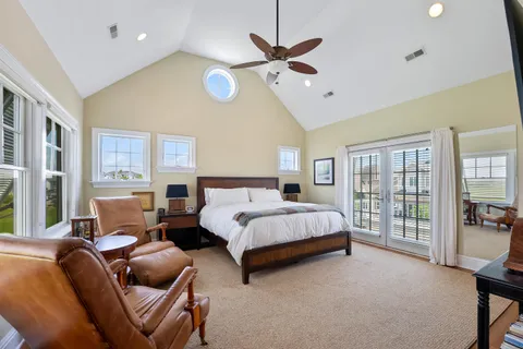 a spacious bedroom with a bed a couch and a chandelier