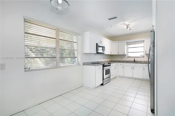 a kitchen with a stove a sink and a microwave