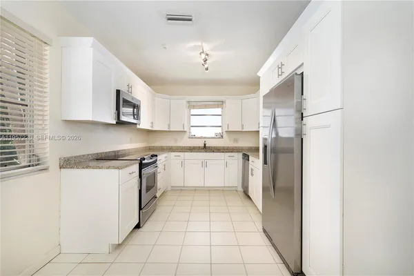a large kitchen with cabinets and stainless steel appliances