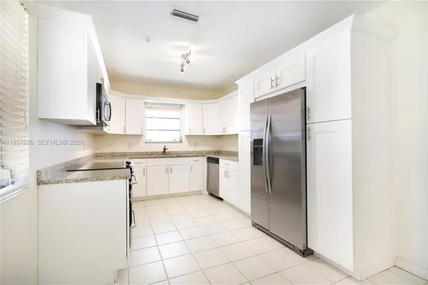 a kitchen with a refrigerator sink and cabinets