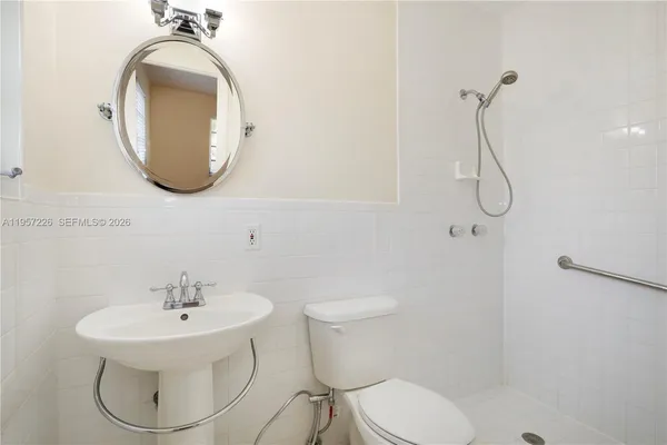 a bathroom with a sink toilet and a mirror