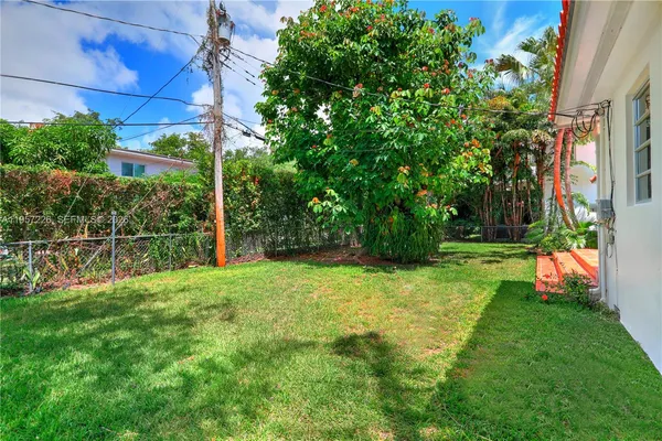 a view of a backyard with table and chairs and potted plants