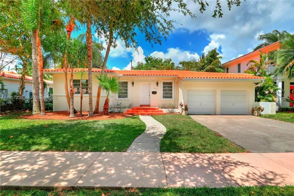 a front view of a house with a yard and a garage